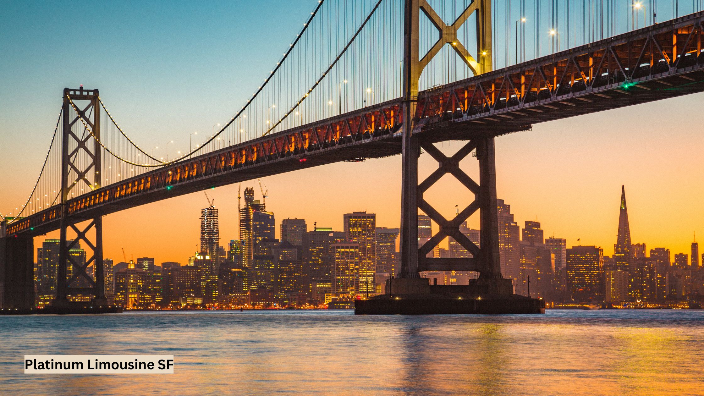 San Francisco skyline at sunset with warm golden light illuminating iconic buildings and the Bay Bridge in the background.